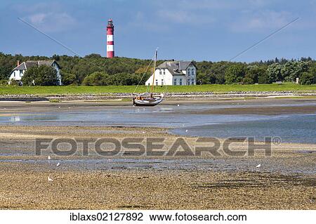 Stock Image - Sailboat stranded at low tide near Wittduen, facing Foehr, Amrum Island, North Frisia, Schleswig-Holstein, Germany, Europe, PublicGround, Europe. Fotosearch