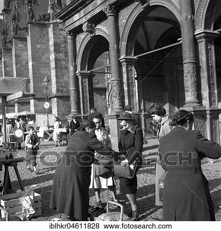 Stock Photo - Seller puts something in the customer's pocket, Freiburger Münstermarkt, around 1950, Freiburg, Germany, Europe. Fotosearch