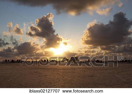 Stock Photo - Silhouette of stilt houses on the beach of St. Peter-Ording at sunset, Sankt Peter-Ording, North Friesland district, Schleswig-Holstein, Germany, Europe. Fotosearch