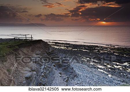 Sunset on a cloudy and showery evening at Kilve Beach, from the cliffs looking out over the Bristol Channel, United Kingdom, Europe View Large Photo Image Stock Photography - Sunset on a cloudy and showery evening at Kilve Beach, from the cliffs looking out over the Bristol Channel, United Kingdom, Europe. Fotosearch