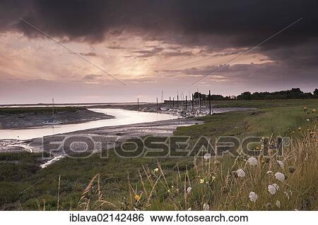 The Brue estuary near Burnham-on-Sea, with the sun shining through the clouds close to sunset, Somerset, England, United Kingdom, Europe View Large Photo Image Stock Photograph - The Brue estuary near Burnham-on-Sea, with the sun shining through the clouds close to sunset, Somerset, England, United Kingdom, Europe. Fotosearch