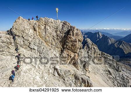Touristen am Gipfelkreuz der Zugspitze, Ausblick nach Tirol, Garmisch-Partenkirchen, Wettersteingebirge, Alpen, Oberbayern, Bayern, Deutschland, Europa View Large Photo Image Stock Photography - Touristen am Gipfelkreuz der Zugspitze, Ausblick nach Tirol, Garmisch-Partenkirchen, Wettersteingebirge, Alpen, Oberbayern, Bayern, Deutschland, Europa. Fotosearch