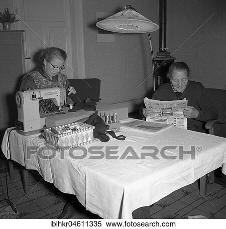 Two women sitting at the table, sewing and newspaper reading, ca. 1955, Freiburg, Germany, Europe View Large Photo Image Stock Photography - Two women sitting at the table, sewing and newspaper reading, ca. 1955, Freiburg, Germany, Europe. Fotosearch
