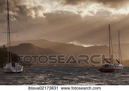 Stock Image - View of Hallin Fell, lit by the autumn sun, with yachts on Ullswater in the foreground, Pooley Bridge, Cumbria, England, United Kingdom, Europe. Fotosearch