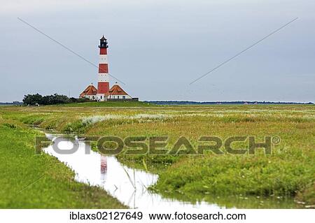 Stock Photo - Westerheversand Lighthouse amid the salt marshes on the Eiderstedt Peninsula, North Frisia, Schleswig-Holstein, Germany, Europe. Fotosearch
