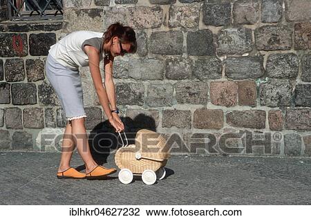 Stock Image - Wife and dog push doll pram, Berlin, Germany, Europe. Fotosearch