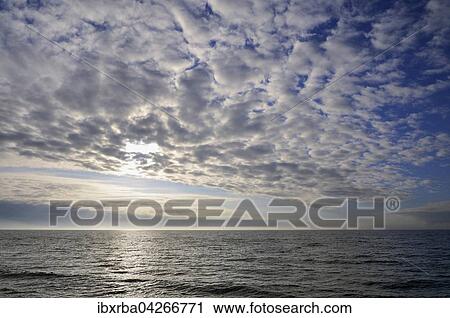 Stock Image - Wolkenhimmel, Wolkenformation vor der tiefstehenden Sonne uber der Ostsee, Vorpommersche Boddenlandschaft, Mecklenburg-Vorpommern, Deutschland, Europa. Fotosearch