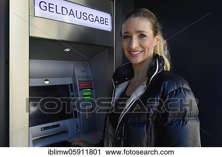 Woman standing in front of an ATM at a savings bank, Waiblingen, Baden-Württemberg, Germany, Europe View Large Photo Image Stock Image - Woman standing in front of an ATM at a savings bank, Waiblingen, Baden-Württemberg, Germany, Europe. Fotosearch