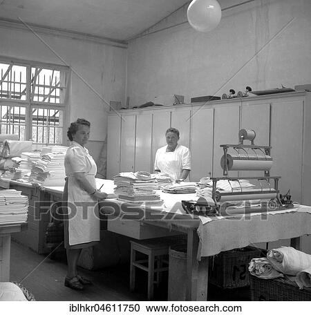 Stock Image - Women folding fabrics around 1950, Freiburg, Germany, Europe. Fotosearch