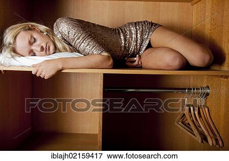 Young woman, 18-25 years, sleeping in wardrobe space in a hotel room View Large Photo Image Stock Photo - Young woman, 18-25 years, sleeping in wardrobe space in a hotel room. Fotosearch