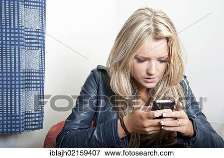 Stock Photo - Young woman, 18-25 years, using an Apple iPhone. Fotosearch