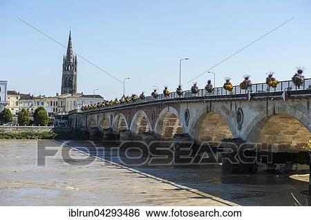 Stock Photograph - Arch bridge over the Dordogne river, at the back the church Eglise Saint-Jean Baptiste, Libourne, Departement Gironde, France, Europe. Fotosearch