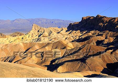Stock Image - Coloured rock formations at sunrise, Zabriskie Point, Death Valley National Park, California, USA, North America. Fotosearch
