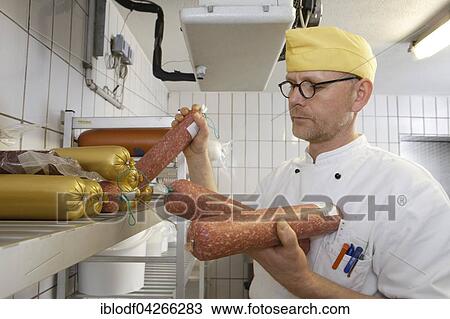 Stock Image - Cook with sausages in the fridge of a canteen kitchen, Catering, Germany, Europe. Fotosearch