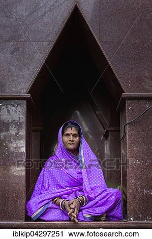 Stock Image - Elderly woman sitting in front of a temple in Pushkar, Rajasthan, India, Asia. Fotosearch