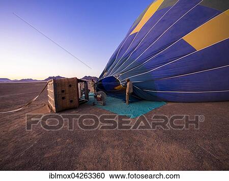 Stock Image - Hot air balloon being filled with air, Kulala Wilderness Reserve, Namib Desert, Tsaris Mountains, Hardap Region, Namibia, Africa. Fotosearch