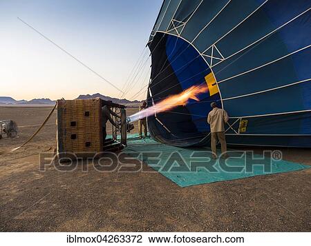 Hot air balloon being heated up, Kulala Wilderness Reserve, Namib Desert, Tsaris Mountains, Hardap Region, Namibia, Africa View Large Photo Image Stock Image - Hot air balloon being heated up, Kulala Wilderness Reserve, Namib Desert, Tsaris Mountains, Hardap Region, Namibia, Africa. Fotosearch