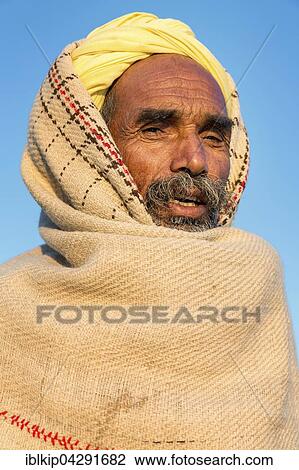 Stock Image - Indian man wearing a yellow turban, Pushkar Camel Fair, Pushkar, Rajasthan, India, Asia. Fotosearch