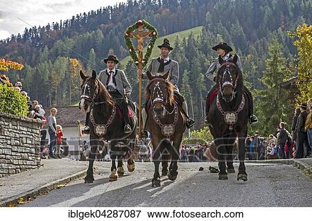 Stock Photo - Leonhardiritt, three riders with decorated horses and cross, Thiersee, Kufstein, Tyrol, Austria, Europe. Fotosearch