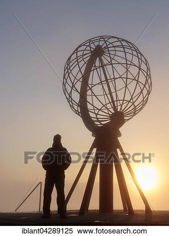 Stock Photography - Man next to the globe at the North Cape platform Nordkapplataet, midnight sun, Nordkapp, Mageroya, Finnmark County, Norway, Europe. Fotosearch