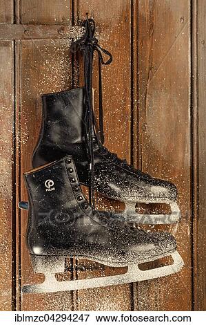 Old ice skates hanging on a wooden door with snowflakes View Large Photo Image Stock Photo - Old ice skates hanging on a wooden door with snowflakes. Fotosearch