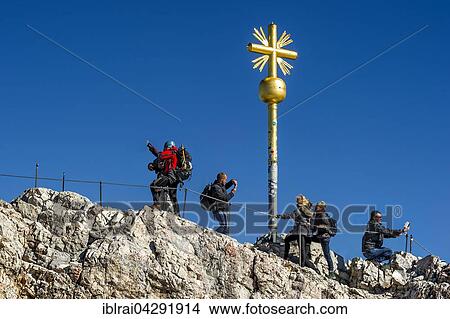 Tourists making selfies and photos, summit cross on the Zugspitze, Garmisch-Partenkirchen District, Wetterstein, Alps, Upper Bavaria, Bavaria, Germany, Europe View Large Photo Image Picture - Tourists making selfies and photos, summit cross on the Zugspitze, Garmisch-Partenkirchen District, Wetterstein, Alps, Upper Bavaria, Bavaria, Germany, Europe. Fotosearch