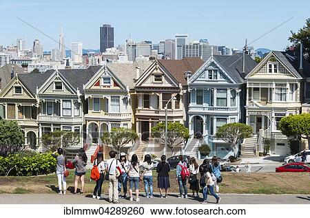 Stock Image - Tourists, Victorian row of houses, Painted Ladies, Postcard Row, Alamo Square, Steiner Street, San Francisco, California, USA, North America. Fotosearch