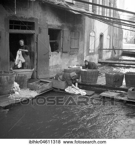Housewives do their laundry on the banks of a river, ca. 1955, Freiburg, Germany, Europe View Large Photo Image Stock Photo - Housewives do their laundry on the banks of a river, ca. 1955, Freiburg, Germany, Europe. Fotosearch