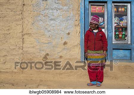 Picture - A local woman is standing in front of the window of her shop, Himalaya, Solu Khumbu, Everest region, Nepal, Asia. Fotosearch