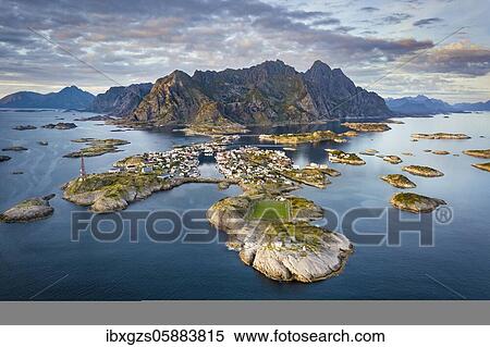 Stock Photography - Aerial view of the island world near the fishing village Henningsvaer, in front peninsula with football field, in the back mountain range Vagakallen with summits Festvagtinden, Budalsdinten and Kvanndalstinden, Vågan, Lofoten, Nordland, Norway, Europe. Fotosearch