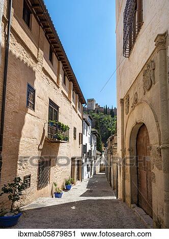 Stock Image - Alley with old house entrance, view of the towers of the Alhambra, Albaicín district, Granada, Andalusia, Spain, Europe. Fotosearch