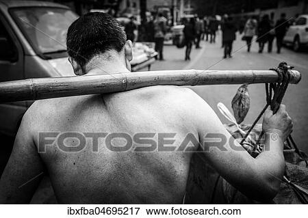 Stock Photo - Bang-bang carriers in a market at the port of Chongqing, the carriers are like a caste of their own, carrying loads for the traders for little money, mostly immigrant workers from rural areas, Chongqing, China, Asia. Fotosearch