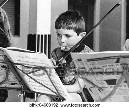 Stock Image - Boy with chewing gum playing the violin, England, Great Britain. Fotosearch