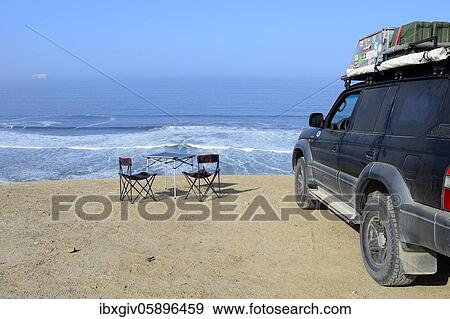 Stock Photo - Camping furniture and off-road vehicles at Supay Beach, Paracas National Reserve, Paracas, Ica Region, Peru, South America. Fotosearch