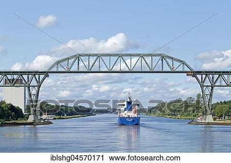 Cargo ship under the Hochdonn railway bridge, Kiel Canal, Schleswig-Holstein, Germany, Europe View Large Photo Image Stock Image - Cargo ship under the Hochdonn railway bridge, Kiel Canal, Schleswig-Holstein, Germany, Europe. Fotosearch