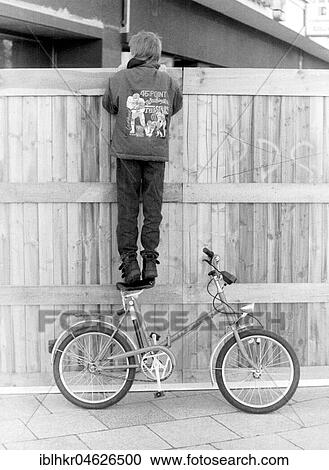 Stock Image - Child stands on a bicycle, ca. 1980s, East Berlin, GDR, Germany, Europe. Fotosearch