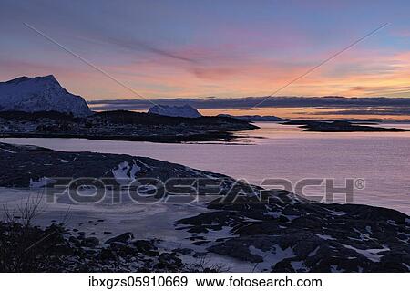 Stock Photo - Coastal landscape, winter at dusk, mountains and sea behind, Langsanden Strand, Sandhornøy, Nordland, Norway, Europe. Fotosearch