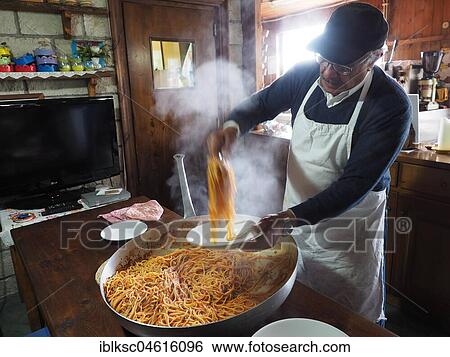 Stock Photograph - Cook served spaghetti in a traditional way in a large pan, restaurant on Monte Epomeo, Ischia, Calabria, Italy, Europe. Fotosearch
