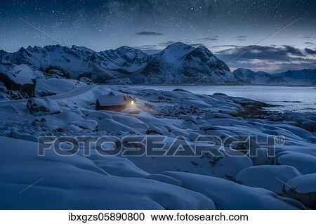 Deep snowy winter landscape by the sea, wooden cabin with warm light on the coast, behind mountains under starry sky, Kleppstad, Nordland, Lofoten, Norway, Europe View Large Photo Image Stock Image - Deep snowy winter landscape by the sea, wooden cabin with warm light on the coast, behind mountains under starry sky, Kleppstad, Nordland, Lofoten, Norway, Europe. Fotosearch
