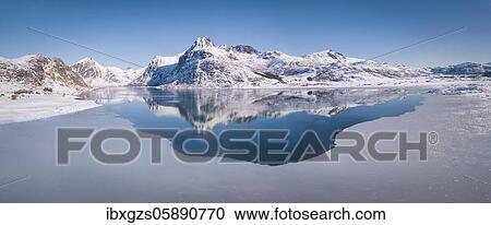 Deep wintry mountain range reflected in the blue sea, large ice sheet, behind mountains Blekktinten and Andopshesten in front of Fjord Flakstadpollen, Nordland, Lofoten, Norway, Europe View Large Photo Image Stock Image - Deep wintry mountain range reflected in the blue sea, large ice sheet, behind mountains Blekktinten and Andopshesten in front of Fjord Flakstadpollen, Nordland, Lofoten, Norway, Europe. Fotosearch