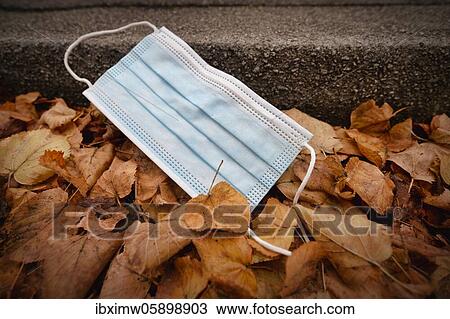 Discarded face mask lying on the ground in autumn foliage, corona crisis, Stuttgart, Baden-Württemberg, Germany, Europe View Large Photo Image Stock Image - Discarded face mask lying on the ground in autumn foliage, corona crisis, Stuttgart, Baden-Württemberg, Germany, Europe. Fotosearch