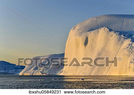 Stock Image - Evening atmosphere with sunlit iceberg, Icefjord, UNESCO World Heritage Site, Disko Bay, West Greenland, Greenland, North America. Fotosearch