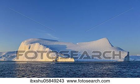 Stock Image - Evening atmosphere with sunlit iceberg, Icefjord, UNESCO World Heritage Site, Disko Bay, West Greenland, Greenland, North America. Fotosearch