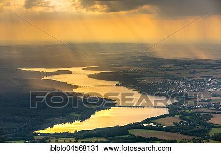 Stock Image - Evening sun reflected in the Möhnesee, reservoir, Sauerland, North Rhine-Westphalia, Germany, Europe. Fotosearch