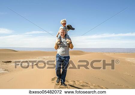 Father walking with piggybacked 2 years old son through Sahara Desert in Morocco, Africa View Large Photo Image Stock Image - Father walking with piggybacked 2 years old son through Sahara Desert in Morocco, Africa. Fotosearch