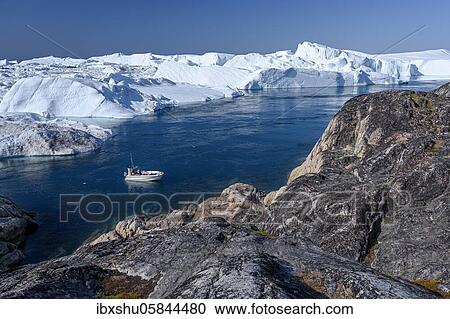 Fishermen with boat in front of gigantic icebergs, UNESCO World Natural Heritage, Ilulissat, Disko Bay, West Greenland, Greenland, North America View Large Photo Image Stock Image - Fishermen with boat in front of gigantic icebergs, UNESCO World Natural Heritage, Ilulissat, Disko Bay, West Greenland, Greenland, North America. Fotosearch