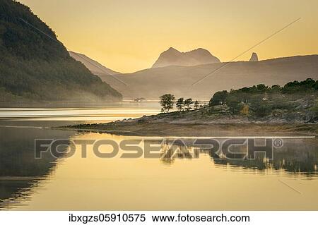 Fjord in the evening light in the haze, in front island with boreal forest, in the back mountains, Innhavet, Nordland, Norway, Europe View Large Photo Image Stock Photography - Fjord in the evening light in the haze, in front island with boreal forest, in the back mountains, Innhavet, Nordland, Norway, Europe. Fotosearch
