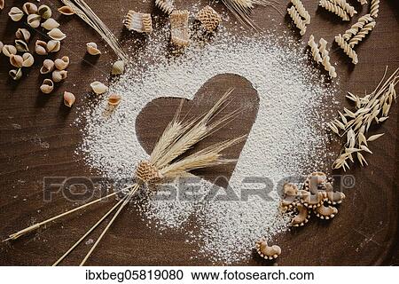 Stock Image - Flour heart with noodles and cereals. Fotosearch