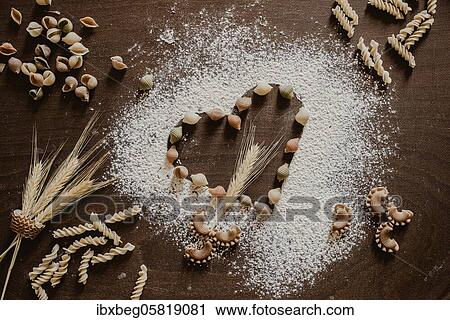 Stock Image - Flour heart with noodles and cereals. Fotosearch