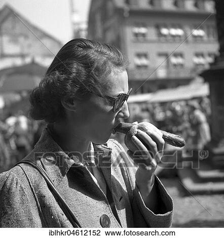 Frau eats bratwurst in bread roll on the market square, Freiburger Münstermarkt, approx. 1945 to 1955, Freiburg, Germany, Europe View Large Photo Image Stock Image - Frau eats bratwurst in bread roll on the market square, Freiburger Münstermarkt, approx. 1945 to 1955, Freiburg, Germany, Europe. Fotosearch